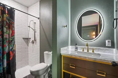 a bathroom with a toilet and a sink and a mirror at 5 Bdr 4,5 Bth Villa - Pool Table - Fenced Yard in Orlando