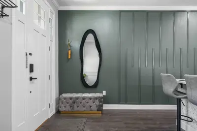 a hallway with a mirror and a ottoman at 5 Bdr 4,5 Bth Villa - Pool Table - Fenced Yard in Orlando