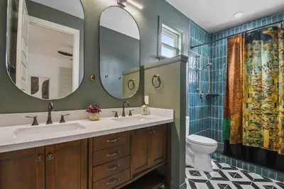 a bathroom with two sinks and a toilet and a mirror at 5 Bdr 4,5 Bth Villa - Pool Table - Fenced Yard in Orlando