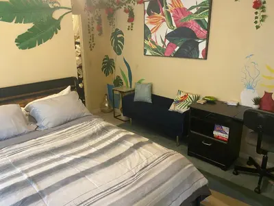 a bedroom with a bed and a desk and a chair at Botanical Tranquility in Orlando