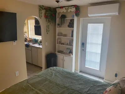a bedroom with a bed and a kitchen with a window at Botanical Tranquility in Orlando