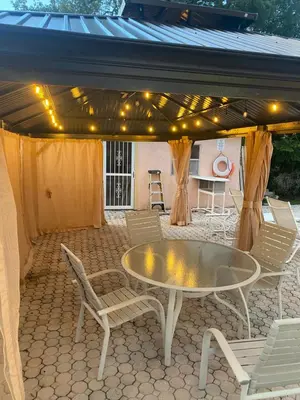 a patio with a table and chairs and a tent at Botanical Tranquility in Orlando