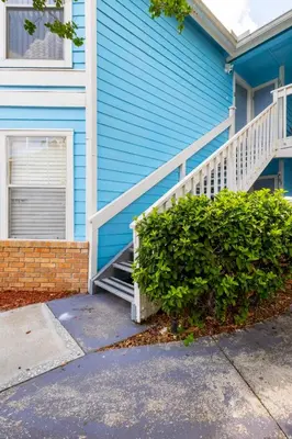 a blue house with a staircase in front at The Villa of Somerset in Kissimmee