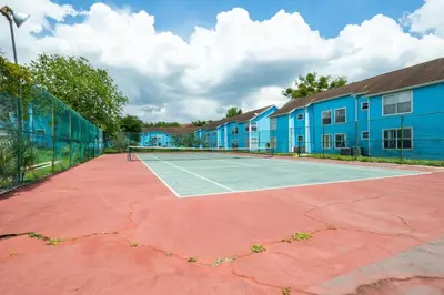 a tennis court in front of a building at The Villa of Somerset in Kissimmee