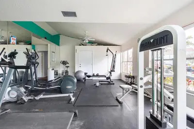 a gym with several treadmills and machines in a room at The Villa of Somerset in Kissimmee
