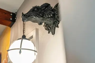 a head of a dragon on a wall next to a light at Beautiful 12Bed11.5Bath House At Bella Vida in Kissimmee