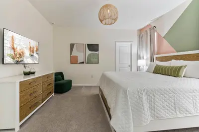 a white bedroom with a bed and a desk at Beautiful 12Bed11.5Bath House At Bella Vida in Kissimmee