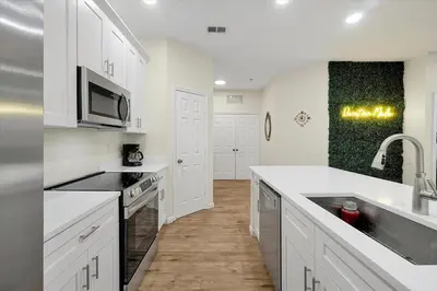 a white kitchen with a sink and a microwave at Windsor Hills Spacious Condo,Pool,Slides,By Disney in Orlando