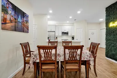 a dining room with a table and chairs and a kitchen at Windsor Hills Spacious Condo,Pool,Slides,By Disney in Orlando