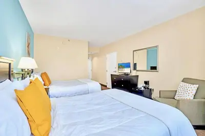 a hotel room with two beds and a television at Apartment with Pool & Hot Tub - Close to Universal Studios in Orlando