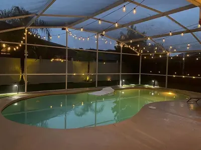 a swimming pool with a canopy and lights at Casa a 3 millas de Disney in Kissimmee