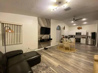 a living room with a couch and a table and a kitchen at Casa a 3 millas de Disney in Kissimmee