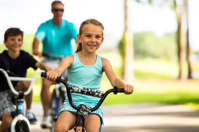 a young girl riding a bike with a man at Villas of Grand Cypress Resort in Orlando
