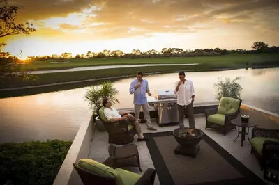 a couple of men standing on a patio next to a lake at Villas of Grand Cypress Resort in Orlando