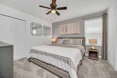 a bedroom with a bed and a ceiling fan at Perfect 9 Bed 5 Bath Home/Games room/ Private pool in Kissimmee