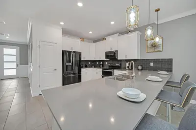 a white kitchen with a large white counter top at Perfect 9 Bed 5 Bath Home/Games room/ Private pool in Kissimmee