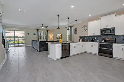 a large kitchen with white cabinets and appliances at AVH-2746-SL in Kissimmee