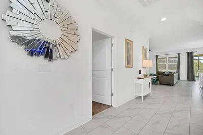 a living room with a large chandelier on the wall at Brand New 6BD, Gameroom / Movie Theater And Pool in Kissimmee