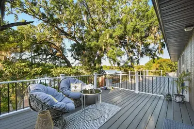 a patio with two chairs and a table on a deck at Spring Lake King Balcony Suite in Orlando