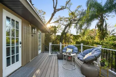 a deck with two chairs and a table on a house at Spring Lake King Balcony Suite in Orlando