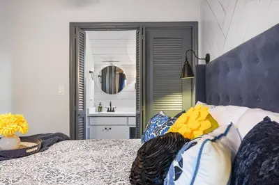a bedroom with a bed with pillows and a sink at Spring Lake King Balcony Suite in Orlando