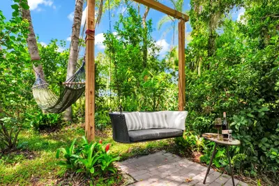 a hammock hanging from a pergola in a garden at Spring Lake King Balcony Suite in Orlando