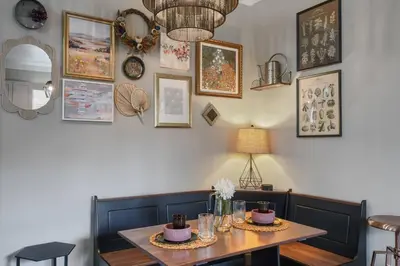 a dining room with a table and some pictures on the wall at 2 King En Suite Fenced Yard Pet Friendly in Orlando