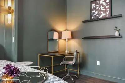 a bedroom with a desk with a mirror and a chair at 2 King En Suite Fenced Yard Pet Friendly in Orlando
