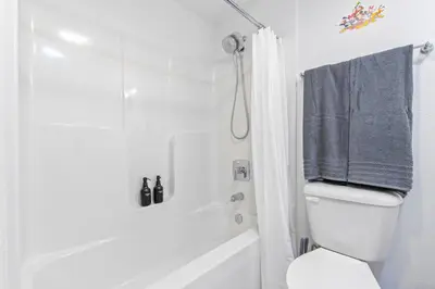 a bathroom with a white toilet and a shower at 15 Mins from Disney World l Theme Room l Pool in Kissimmee
