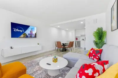 a living room with a couch and a table at 15 Mins from Disney World l Theme Room l Pool in Kissimmee