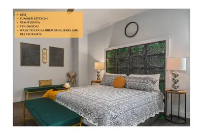 a bedroom with a bed and a clock on the wall at Pool Table, BBQ, Walking Distance to Local Gems in Orlando