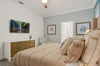 a white bedroom with a bed and a dresser at Welcome to the Ultimate Vacation Wonderland in Kissimmee