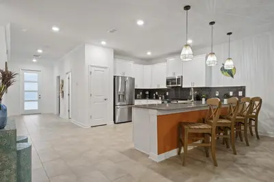 a kitchen with white cabinets and a table and chairs at Welcome to the Ultimate Vacation Wonderland in Kissimmee