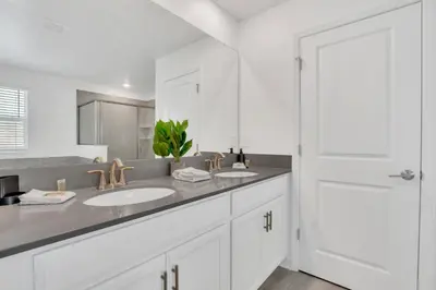 a white bathroom with two sinks and a mirror at Mickey's Retreat /Pool With Water Slide/ Game Room in Kissimmee