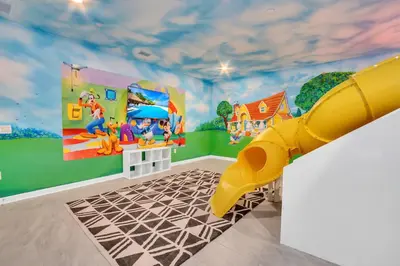 a childs play room with a yellow slide at Mickey's Retreat /Pool With Water Slide/ Game Room in Kissimmee