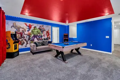 a living room with a ping pong table and blue walls at Mickey's Retreat /Pool With Water Slide/ Game Room in Kissimmee