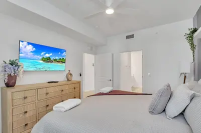 a bedroom with a bed and a tv on the wall at Stylish 2-Bed Condo With Resort Amenities/Patio in Kissimmee