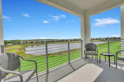 a porch with two chairs and a view of the ocean at Stylish 2-Bed Condo With Resort Amenities/Patio in Kissimmee