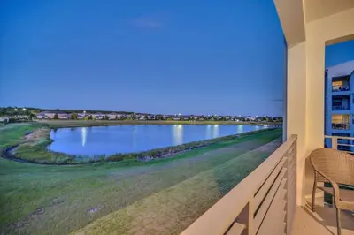 a balcony with a view of a golf course at Stylish 2-Bed Condo With Resort Amenities/Patio in Kissimmee