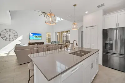 a kitchen and living room with a sink and a couch at Amazing Brand New 5BD, Resort Home/Games Room/Pool in Kissimmee