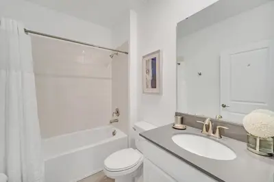 a white bathroom with a sink and a toilet at Amazing Brand New 5BD, Resort Home/Games Room/Pool in Kissimmee