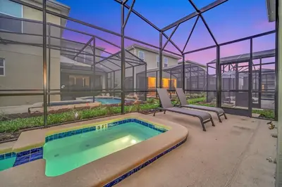 a swimming pool with two lounge chairs next to a building at 5BR Family Haven Near Disney with Private Pool in Kissimmee