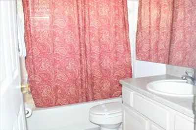a bathroom with a red shower curtain and a toilet at 6 bed property - Indian Creek in Kissimmee