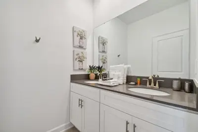 a white bathroom with a sink and a mirror at 5Q/4B luxuosa casa *Acesso ao Resort* in Kissimmee