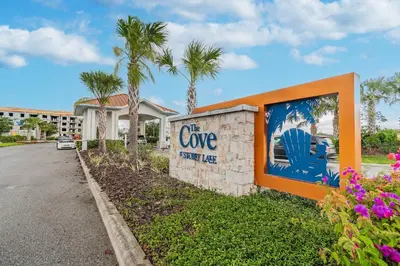 a sign for the cove resort with palm trees at 5Q/4B luxuosa casa *Acesso ao Resort* in Kissimmee