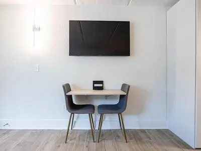 a table with two chairs and a laptop on it at Lovely 1BR Suite at Orlando with pool view in Kissimmee