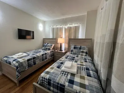 two twin beds in a room with a tv at 12 - Universal Studios, International Dr in Orlando