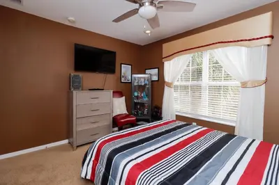 a bedroom with a bed and a dresser and a window at Spacious Emerald Island Resort Home with Pool Spa and Resort Amenities near Disney in Kissimmee