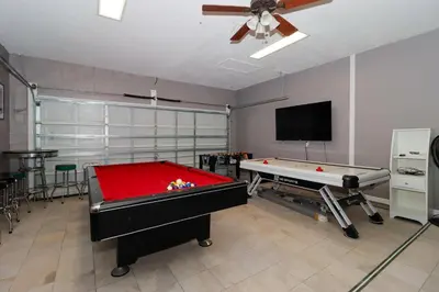 a living room with a pool table and a tv at Spacious Emerald Island Resort Home with Pool Spa and Resort Amenities near Disney in Kissimmee