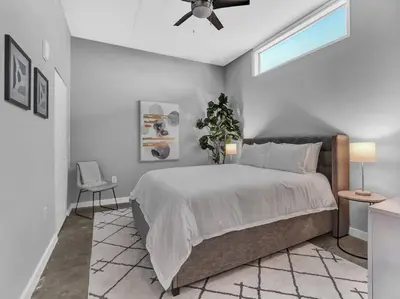 a bedroom with a bed and a ceiling fan at Lake Eola Thornton Park Modern 2Bed 2Bath Secure Parking in Orlando